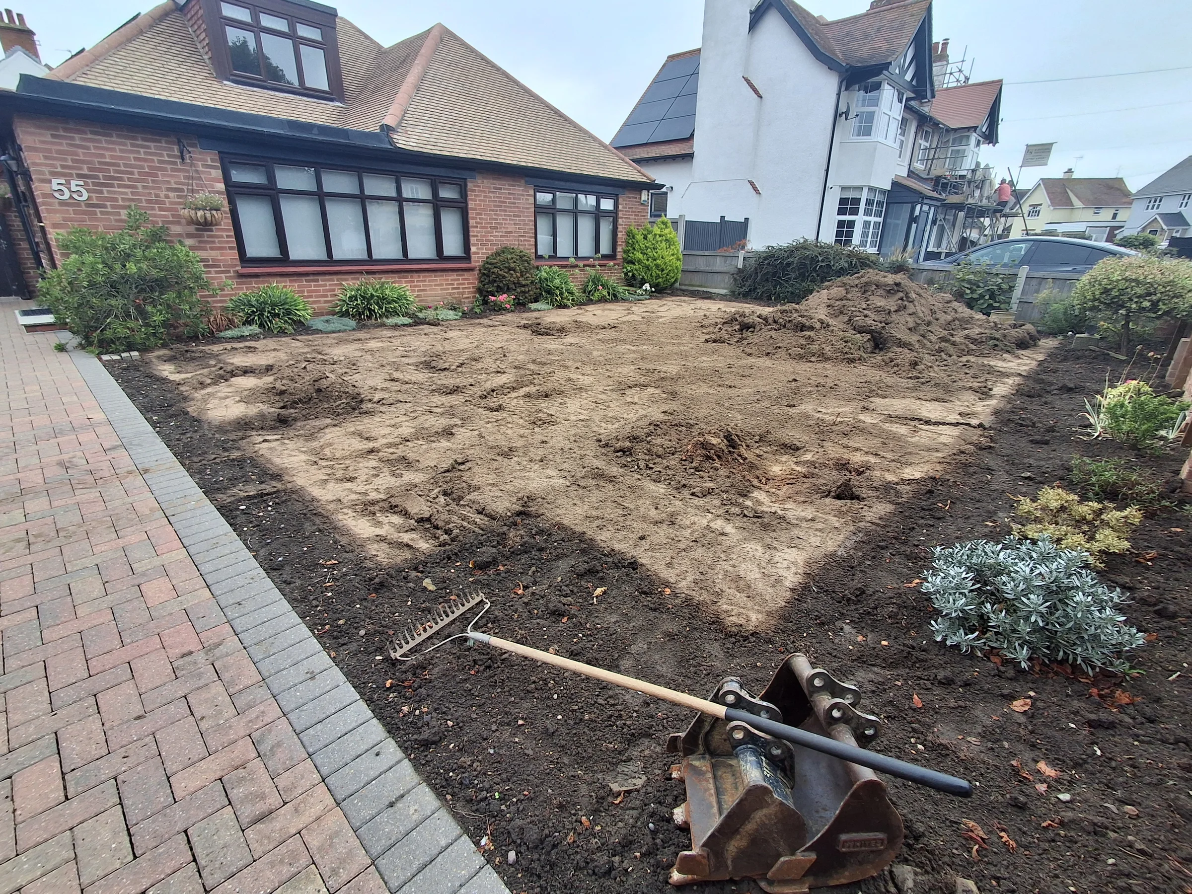 Removing the higher lawn area into piles for removal with a digger